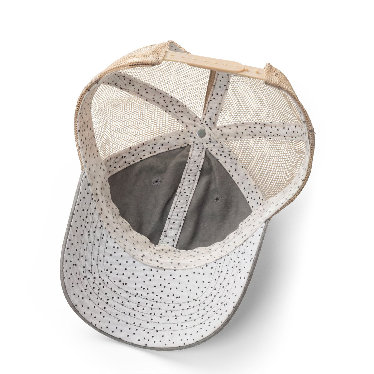 Baseball cap with mesh back and polka dot pattern on a white background